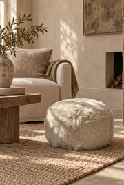 Linen sheepskin pouffe with its natural softly irregular shape in the Rare Breed room setting